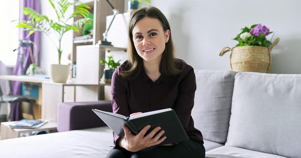 Woman in consulting room holding journal