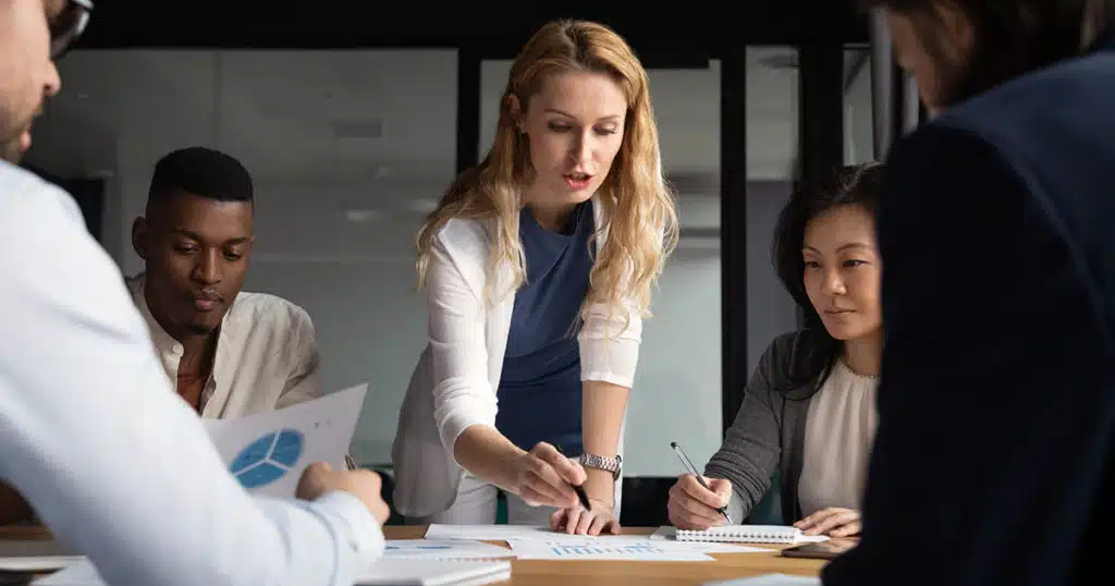 Woman pointing out aspects of a chart in a team meeting